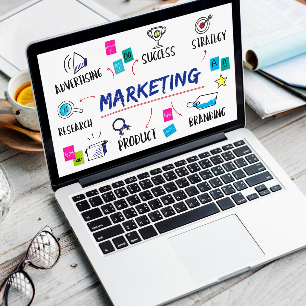 Portátil mostrando esquema de marketing con palabras clave como estrategia, producto, branding e investigación: planificación de campañas y posicionamiento digital.